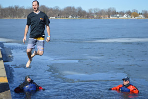 Phil Kuhn jumps into the cold water of Center Lake Saturday during the 2016 Polar Plunge benefitting Special Olympics as members of the Warsaw Police Department Dive Team look on. Photo by David Slone, Times-Union