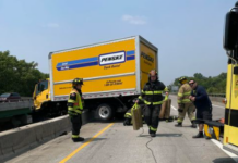 Two rescued as rental truck sits on edge of bridge